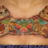 Identical looking colored collarbone tattoo with maneki neko japanese lucky cats and lotus flower