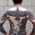Illustrative style black ink whole back tattoo of large bird with ships