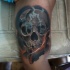 Illustrative style colored biceps tattoo of human skull with smoke