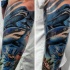 Illustrative style colored forearm tattoo of underwater sharks and fishes
