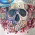 Illustrative style colored human skull tattoo on chest with lettering