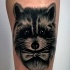 Illustrative style colored leg tattoo of raccoon with bow