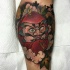 Illustrative style colored leg tattoo of big daruma doll with flowers