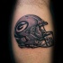 Illustrative style colored leg tattoo of American football helmet