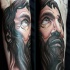 Illustrative style colored religious man portrait tattoo on forearm