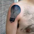 Illustrative style colored shoulder tattoo of bulb stylized with heart shaped thread