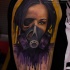 Illustrative style colored shoulder tattoo of woman with gas mask