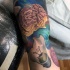 Illustrative style colored sleeve tattoo of human brain with broken bulb