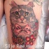 Illustrative style colored thigh tattoo of funny cat with flowers