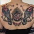 Illustrative style colored upper back tattoo of birds with flowers and symbols