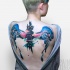 Illustrative style colored wings with symbols tattoo on back