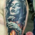 Illustrative style colored woman portrait tattoo on shoulder with candle