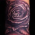 Illustrative style colored wrist tattoo of black rose
