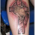 Tatuaje en la pierna,
cruz celta con manos que oran