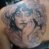 Impressive gorgeous looking black ink scapular tattoo of woman with flowers