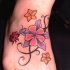 Tatuaje en el pie, flores bicolores y mariquita