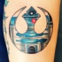 Tatuaje en el antebrazo, emblema de la Alianza Rebelde con dibujo de R2D2