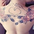 Tatuaje en la espalda, rosas pintadas y manos no pintadas en forma de corazón