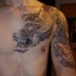 Tatuaggio sul petto e il braccio il dragone grande