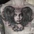 Large black and white chest tattoo of demonic woman with skull