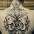 large black ink back tattoo of cool butterfly with flowers