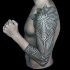 Large black ink ornamental style tattoo on sleeve