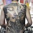 Large black ink whole back tattoo of Buddha statue with dragon