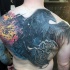 Large colored whole back tattoo of crow with blast and mechanisms