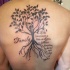 Tatuaje en la espalda, árbol de la vida y inscripción