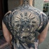 Large whole back tattoo of creepy monster with clock and skulls
