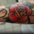 Tatuaje en el antebrazo, rosa roja con letras
