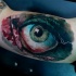 Lifelike colored biceps tattoo of bloody human eye