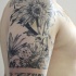 Lifelike natural looking shoulder tattoo of realistic flowers