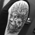 Lion's head in flowers tattoo on shoulder in engraving style