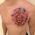 Lion's head with multicolored paint drips tattoo on chest in watercolor style