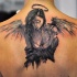 Little black ink abstract sad angel tattoo on upper back