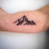 piccolo inchiostro nero  montagna  tatuaggio su bicipite
