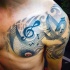 Tatuaje en el hombro, notas musicales y clave de sol