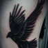 Tatuaje en el costado,  cuervo negro que vuela