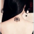 piccolo fiore loto nero tatuaggio sulla nuca