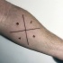 Tatuaje en el antebrazo, cruz con letras simple misteriosa