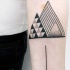 Tatuaje en el antebrazo, triángulos  estilizados de tinta negra, estilo geométrico
