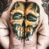 Tatuaje de cráneo dorado  en los dedos