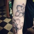 Tatuaje en el antebrazo, flores exquisitas transparentes, tinta negra