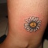 piccolo fiore camomilla di pace tatuaggio su caviglia