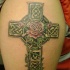 bella croce celtica irlandese con rose rosse tatuaggio sulla spalla