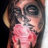 Tatuaje en el brazo,
chica muerta con la  rosa en la mano