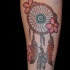 Tatuaje en el antebrazo, atrapasueños con flores diminutas