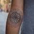 Tatuaje en el antebrazo, mandala gris