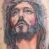 Tatuaje en el brazo,
cara de jesús  en corona de espinas